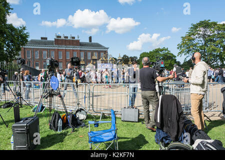 Ein Nachrichten Reporter und Kameramann mit einem Stück zu Kamera vor den Toren des Kensington Palace. Erinnerung an Prinzessin Diana, 20 Jahre nach ihrem Tod. Stockfoto