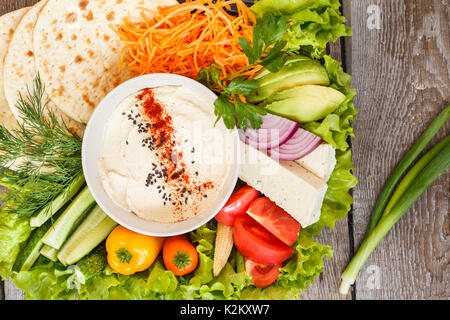 Hummus mit Gemüse und Tofu, vegetarischen Snack, Ansicht von oben. Liebe für eine gesunde vegane Ernährung Konzept. Stockfoto