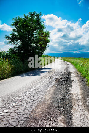 Schlechte Straße gerissen und beschädigt Stockfoto