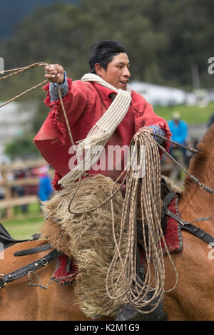 Juni 3, 2017 Machachi, Ecuador: Nahaufnahme von indigenen Quechua Cowboy in Bewegung auf dem Pferderücken traditionell gekleidete Umgang mit Lasso zu Pferd Stockfoto