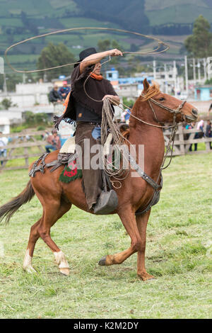 Juni 3, 2017 Machachi, Ecuador: Nahaufnahme von Andinen Cowboy zu Pferd traditionell auf dem Pferd arbeiten in Feld angezogen Stockfoto