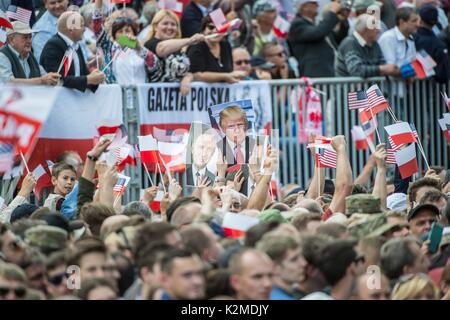 Polnische Bürger wave Flags und halten Sie Fotos von US-Präsident Donald Trump und der polnische Präsident Andrzej Duda während einer Zeremonie an der Statue zum Gedenken an den polnischen Aufstand von 1944 gegen die deutschen Besatzer vom 6. Juli 2017 in Warschau, Polen. Stockfoto
