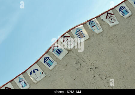 Einige Flags oder BUNTING an der Seite einer Strandhütte mit Umkleidekabinen und ein Thema der nautischen Küste marine Meer Küste maritime Stockfoto