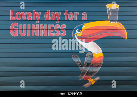 Malte Guinness Schild mit einem Slogan und eine toucan Balancing ein Bier auf einer Wand in Orillia Ontario Kanada. Stockfoto