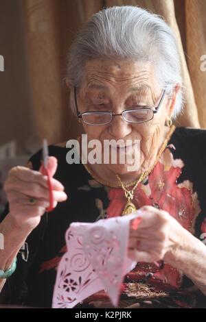 (170831) - yantai, Aug 31, 2017 (Xinhua) - Lin Guimao, 103, macht papercuttings in Yantai, Provinz Shandong, China, August 30, 2017. Lin gelernt papercutting Fähigkeiten als Kind, und jetzt immer noch gerne das Hobby. (Xinhua / Shen Jizhong) (Ry) Stockfoto