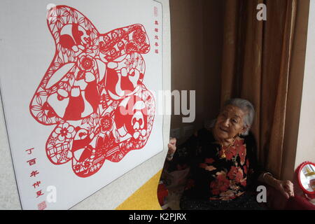 (170831) - yantai, Aug 31, 2017 (Xinhua) - Lin Guimao, 103, macht papercuttings in Yantai, Provinz Shandong, China, August 30, 2017. Lin gelernt papercutting Fähigkeiten als Kind, und jetzt immer noch gerne das Hobby. (Xinhua / Shen Jizhong) (Ry) Stockfoto