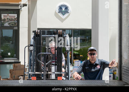 West Palm Beach, Florida, USA. 31 Aug, 2017. Ballpark Direktor Thomas Bell, Links, betreibt ein Gabelstapler wie Greg Sargent, 27, steigt in einem der 53 m langen Auflieger, die Lieferungen für die Houston am Baseballstadion der Palme Strände geparkt in West Palm Beach, Fla., auf Donnerstag, 31. August 2017. Die Houston Astros Baseball Mannschaft lobt Palm Beach County Bewohner für ein Größer-als-Antwort auf die Anforderung des Team für Spenden für die Opfer des Hurrikans Harvey Hilfe erwartet. Die unerwartete Reaktion veranlasst hat, das Team in einem zweiten Fahrzeug zu senden liefert t durchführen Stockfoto