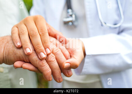 Nahaufnahme junge Ärztin Holding behinderte ältere Menschen die zitternde Hand Stockfoto