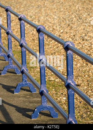 Blau lackiertem Metall Geländer entlang Eastbourne Strandpromenade neben dem Fußweg und Kiesstrand, England, Großbritannien Stockfoto