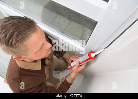 Hohe Betrachtungswinkel und der junge Mann in der gesamten Anwendung Silikondichtmittel Stockfoto