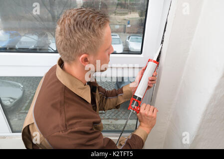 Hohe Betrachtungswinkel und der junge Mann in der gesamten Anwendung Silikondichtmittel Stockfoto