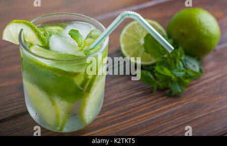 Mojito mit Limette und Minze auf einem Holztisch Stockfoto