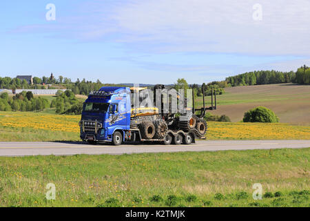 HALIKKO, FINNLAND - Juni 4, 2017: Blaue Volvo FH 13 von Juha Holm Oy Hols moderne Ponsse Forstmaschinen entlang der Autobahn bis Anfang Sommer ländlichen landsca Stockfoto