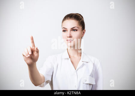 Junger Arzt zeigt mit dem Finger. Stockfoto