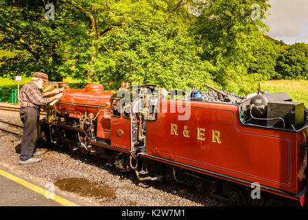 Treiber polieren Dampfmaschine auf der Ravenglass und Eskdale Railway an Dalesgarth station Stockfoto