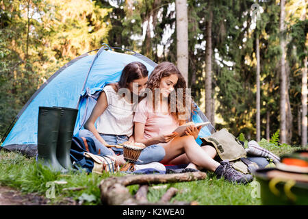 Teenage Mädchen vor Zelten im Wald. Stockfoto