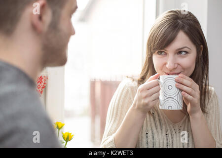 Fröhliche Frau im Gespräch mit Menschen, der durch das Fenster Stockfoto