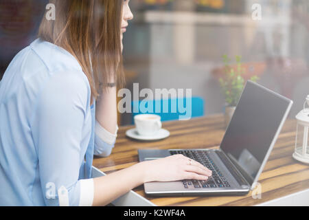 Frau Tippen auf Notebook im Restaurant Stockfoto