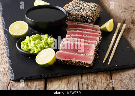 Sesamsamen verkrusteten Thunfisch serviert mit Wasabi und Sauce Nahaufnahme auf dem Tisch. Horizontale Stockfoto