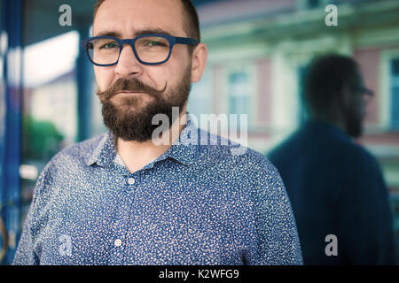 Mann außerhalb der Gebäude aus Glas Stockfoto