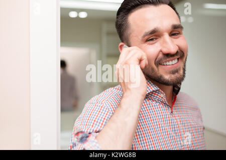 Lächelnder Mann, der nette Anruf im Badezimmer. Stockfoto