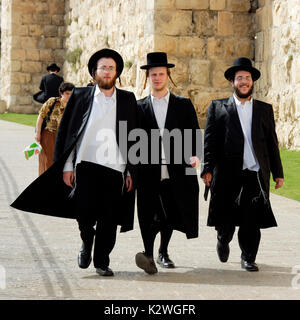 Orthodoxe Juden wandern entlang der Stadtmauer in der Nähe von Jaffa, der Eingang zum westlichen Rand der Altstadt von Jerusalem. Israel Stockfoto