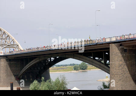 NIJMEGEN, Niederlande - 16 Juli 2013 Menschen aus der ganzen Welt gehen über de Brücke in Nijmegen um 50 Kilometer pro Tag, vier Tage lang. Stockfoto