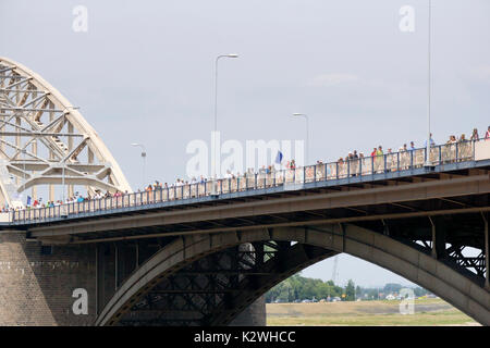 NIJMEGEN, Niederlande - 16 Juli 2013 Menschen aus der ganzen Welt gehen über de Brücke in Nijmegen um 50 Kilometer pro Tag, vier Tage lang. Stockfoto