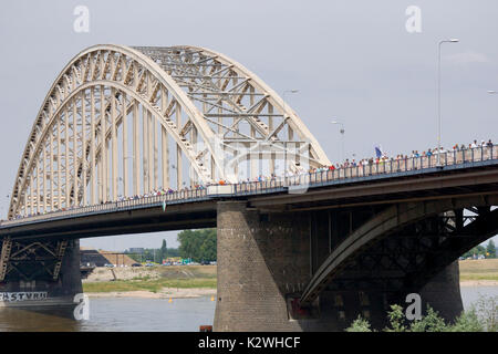 NIJMEGEN, Niederlande - 16 Juli 2013 Menschen aus der ganzen Welt gehen über de Brücke in Nijmegen um 50 Kilometer pro Tag, vier Tage lang. Stockfoto