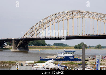 NIJMEGEN, Niederlande - 16 Juli 2013 Menschen aus der ganzen Welt gehen über de Brücke in Nijmegen um 50 Kilometer pro Tag, vier Tage lang. Stockfoto