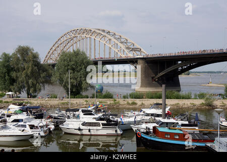 NIJMEGEN, Niederlande - 16 Juli 2013 Menschen aus der ganzen Welt gehen über de Brücke in Nijmegen um 50 Kilometer pro Tag, vier Tage lang. Stockfoto