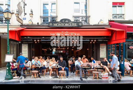 Menschen, die von einem Cafe in der Rue Montorgueil, Paris, Frankreich. Stockfoto