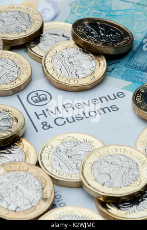 Eine HM Umsatz & Zoll Briefkopf durch neue £1 Münzen und einen € 5 Hinweis umgeben. Stockfoto