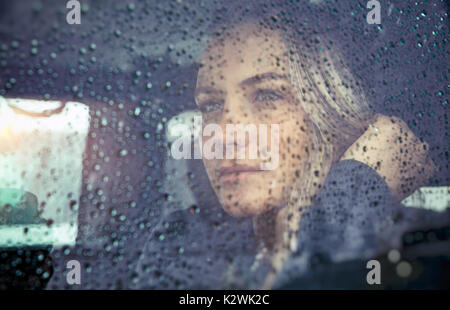 Porträt einer wunderschönen traurige Frau im Auto im regnerischen Wetter sitzen, nachdenkliches Mädchen durch das Fenster Glas mit Regentropfen suchen, Herbst melanchol Stockfoto