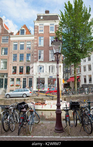 Holland, Norden, Amsterdam, Fahrräder direkt am Canal geparkt. Stockfoto