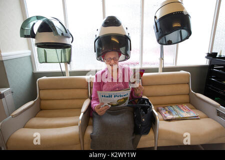 Altersrentner in ihr Haar in einer Haube Haartrockner Lockenstäbe bei einem Damen Friseur, England tragen getrocknet, Vereinigtes Königreich Stockfoto
