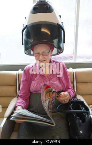 Altersrentner in ihr Haar in einer Haube Haartrockner Lockenstäbe bei einem Damen Friseur, England tragen getrocknet, Vereinigtes Königreich Stockfoto