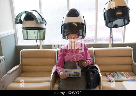Altersrentner in ihr Haar in einer Haube Haartrockner Lockenstäbe bei einem Damen Friseur, England tragen getrocknet, Vereinigtes Königreich Stockfoto