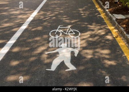 Gemalten Schildern auf Asphalt für Fußgänger- und Fahrradwege, Sommer. Stockfoto