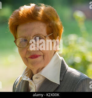Portrait von Fröhliche Frau in alten Park. Alter 80 Jahre. Eine Frau in einem Anzug. Stockfoto