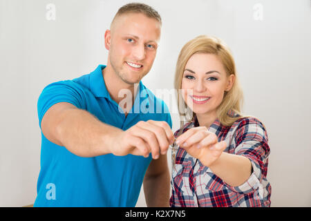 Portrait von glückliches junges Paar hält Tasten Stockfoto