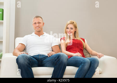 Porträt der jungen Glückliches Paar auf dem Sofa Stockfoto