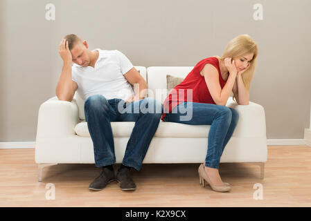 Deprimiert junges Paar auf einem Sofa zu Hause sitzen Stockfoto