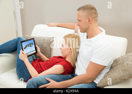 Junges Paar auf Sofa Video auf digitalen Tablet Stockfoto