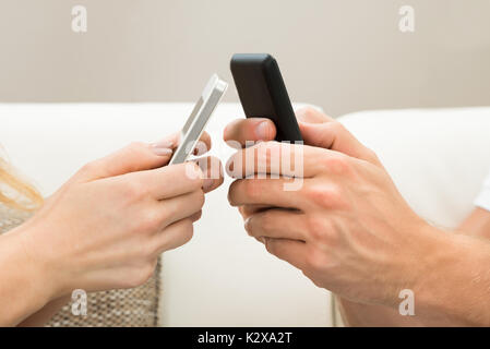In der Nähe von zwei Hände halten Handy Stockfoto