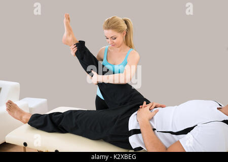 Junge weibliche Kursleiter helfen, Menschen für die Ausübung Stockfoto