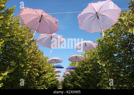 Bunte hängen Regenschirme füllen Sie den Himmel über den Weg. Stockfoto