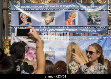 Wie Massen der royalistischen Gratulanten versammeln, eine spontane Memorial von Blumen, Fotos und Erinnerungsstücke wächst außerhalb der Kensington Palace, die königliche Residenz von Prinzessin Diana, die bei einem Autounfall in Paris starb vor genau 20 Jahren, am 31. August 2017, in London, England. 1997 Ein Meer von floral Tribute füllten auch dieser Bereich des Royal Park sowie in der Mall, wo ihre Beerdigung übergeben. Damals wie heute - ein royalisten trauerte das Volk der Prinzessin, einen betitelten geprägt durch den damaligen Premierminister Tony Blair. Stockfoto