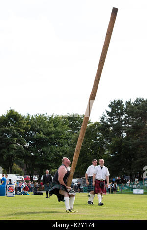 Ballater, Schottland - Aug 10, 2017: Ein Mitbewerber in der CABER toss, traditionelle Schottische Highland Games Ereignis, welches mit Caber. Stockfoto