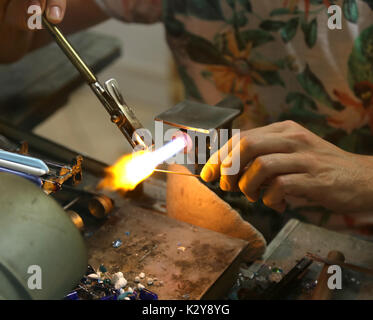 Glasmacher beim Schmelzen und formen Sie das Glas mit einem sehr hohen Temperatur Flamme in seiner handwerklichen Übung in Italien Stockfoto